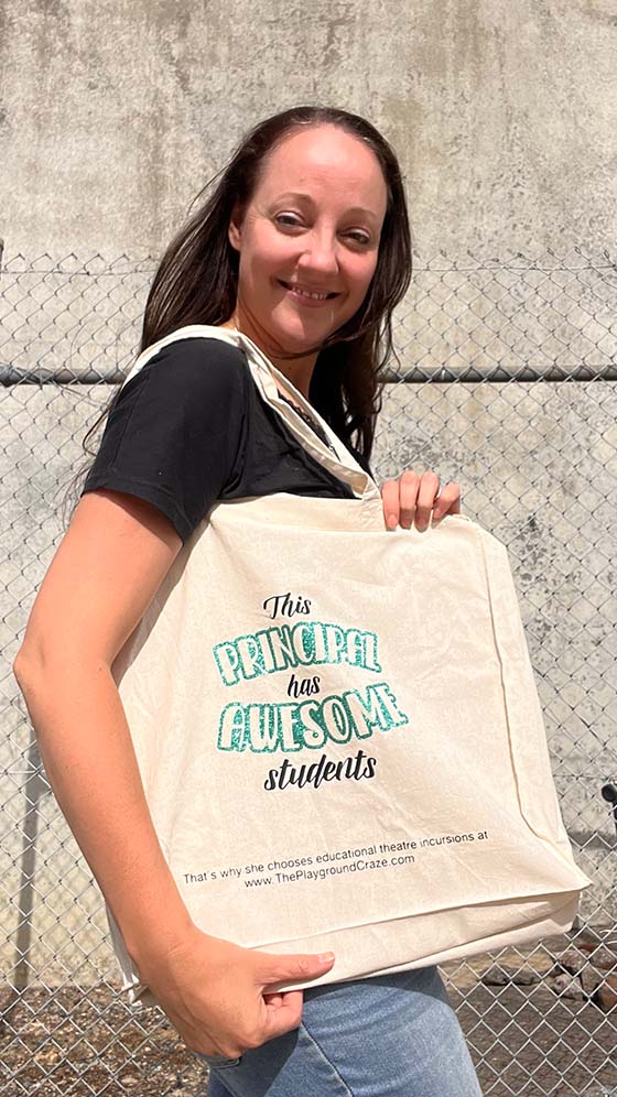 Woman displays tote bag that says 'This Principal has Awesome Students'